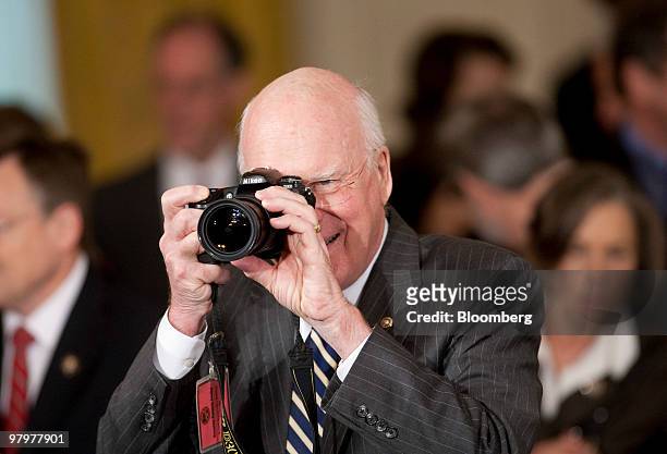 Patrick Leahy, a Democrat from Vermont, takes photographs before U.S. President Barack Obama signs the health insurance reform bill in the East Room...