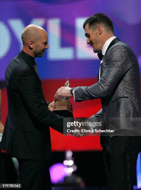 Brian Boyle of the New Jersey Devils accepts the Bill Masterton Memorial Trophy for perseverance and dedication to hockey onstage from Craig Anderson...