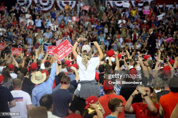 Attendees take photographs during a rally with U.S. President Donald Trump in Duluth, Minnesota, U.S., on Wednesday, June 20, 2018. Trump reversed...