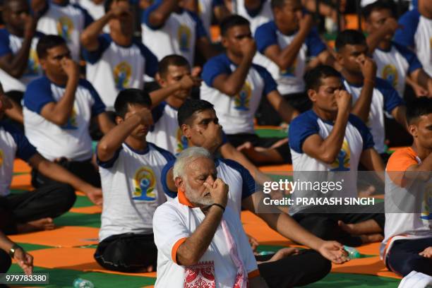 Indian Prime Minister Narendra Modi participates in a mass yoga session along with other practitioners to mark International Yoga Day at the Forest...