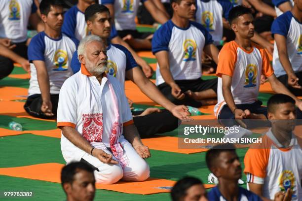 Indian Prime Minister Narendra Modi participates in a mass yoga session along with other practitioners to mark International Yoga Day at the Forest...