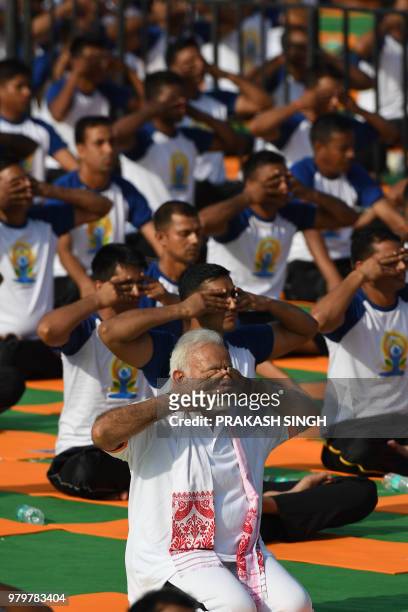 Indian Prime Minister Narendra Modi participates in a mass yoga session along with other practitioners to mark International Yoga Day at the Forest...