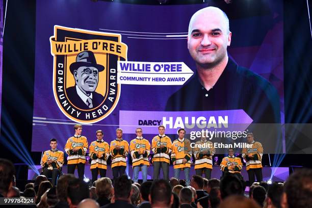 Members of the Humboldt Broncos stand onstage as Darcy Haugan is presented with the Willie O'Ree Community Hero Award at the 2018 NHL Awards...