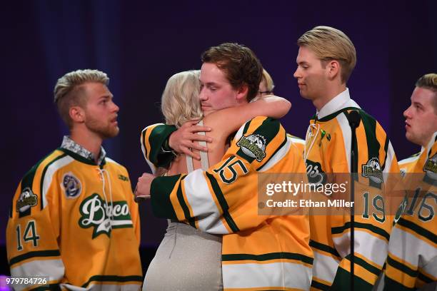 Members of the Humboldt Broncos hug Christina Haugan, wife of Humboldt Broncos coach Darcy Haugan, after accepting the Willie O'Ree Community Hero...