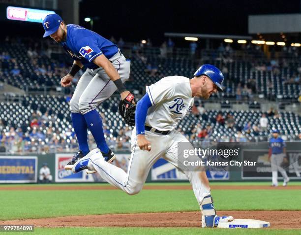 Kansas City Royals' Hunter Dozier reaches first as the throw to Texas Rangers third baseman Joey Gallo was high in the seventh inning on Wednesday,...