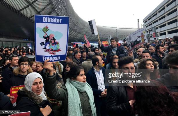 March 2018, Germany, Duesseldorf: Protestors standing at the airport holding an anti-Erdogan. Demonstrators gathered at Duesseldorf Airport to...