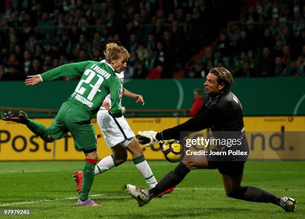 Tim Wiese of Bremen and Michael Thurk of Augsburg compete for the ball during the DFB Cup Semi Final match between SV Werder Bremen and FC Augsburg...