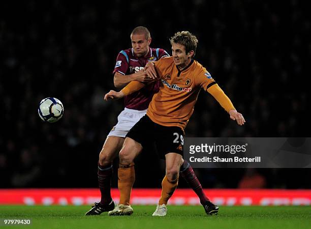 Kevin Doyle of Wolverhampton Wanderers is challenged by Matthew Upson of West Ham United during the Barclays Premier League match between West Ham...