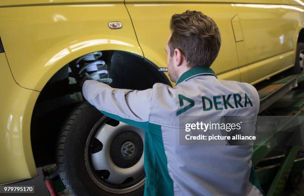 March 2018, Germany, Stuttgart: An employee of the vehicle inspection company Dekra checks the suspension of a VW T5 diesel in the course of a...