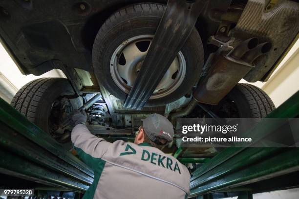 March 2018, Germany, Stuttgart: An employee of the vehicle inspection company Dekra checks the underbody of a VW T5 diesel in the course of a general...