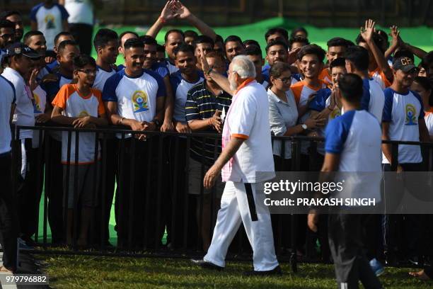 Indian Prime Minister Narendra Modi greets participants following the conclusion of a mass yoga session along with other practitioners to mark...