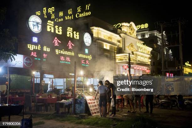 Tourists look at a menu at a restaurant near the New Mei Gao Mei casino in Sihanoukville, Cambodia, on Friday, March 30, 2018. It's against the law...