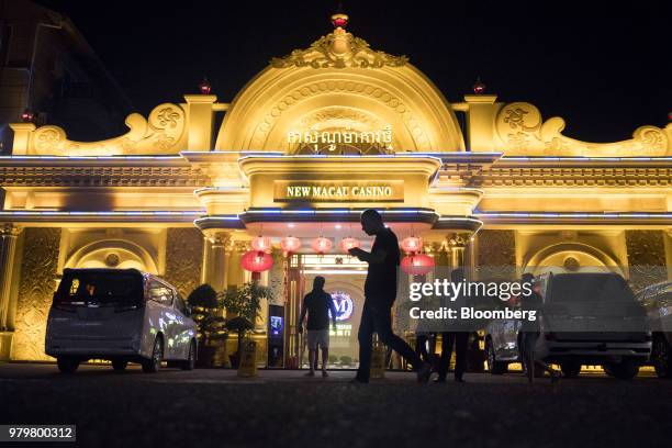 Pedestrian is silhouetted while walking past the New Macau casino illuminated at night in Sihanoukville, Cambodia, on Friday, March 30, 2018. It's...