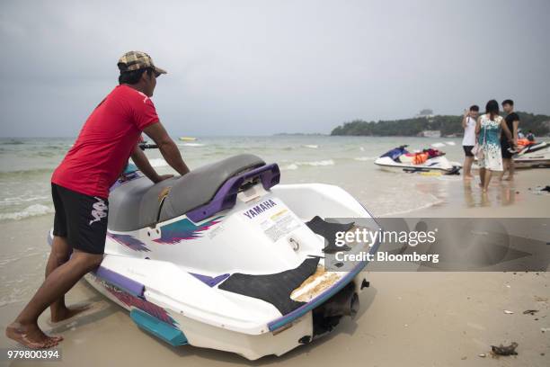 Tourists interact with a jet ski operator on Ochheuteal Beach in Sihanoukville, Cambodia, on Saturday, March 31, 2018. It's against the law for...