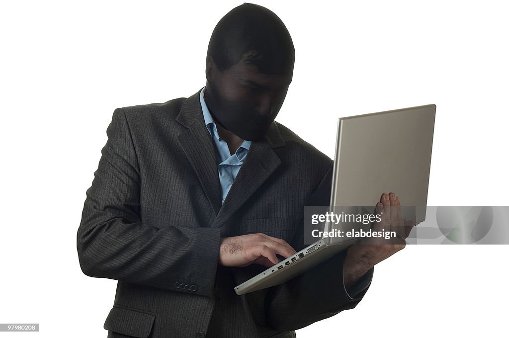 Hombre en un traje de máscara de retención usando computadora portátil