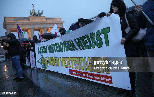 March 2018, Germany, Berlin: Some two hundred Kurs protest with a banner reading 'Afrin verteidigen heisst das Leben verteidigen' against the Turkish...