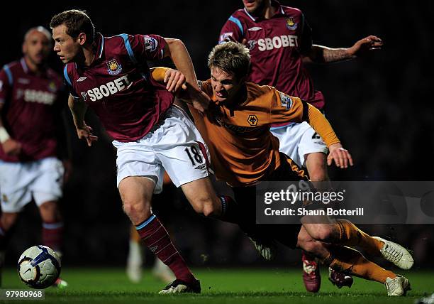 Kevin Doyle of Wolverhampton Wanderers is challenged by Jonathan Spector of West Ham United during the Barclays Premier League match between West Ham...