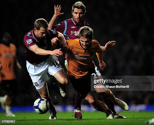 Kevin Doyle of Wolverhampton Wanderers is challenged by Jonathan Spector of West Ham United during the Barclays Premier League match between West Ham...
