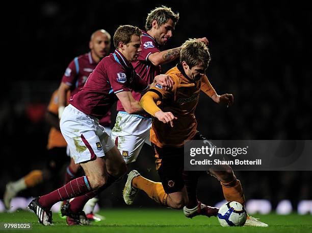 Kevin Doyle of Wolverhampton Wanderers is challenged by Jonathan Spector and Valon Behrami of West Ham United during the Barclays Premier League...