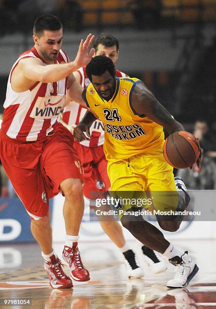 Linas Kleiza, #11 of Olympiacos Piraeus competes with Qyntel Woods, #24 of Asseco Prokom Gdynia during the Euroleague Basketball 2009-2010 Play Off...