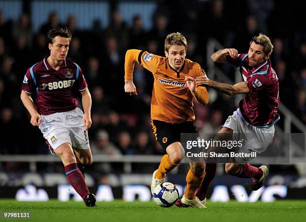 Kevin Doyle of Wolverhampton Wanderers is challenged by Valon Behrami and Scott Parker of West Ham United during the Barclays Premier League match...