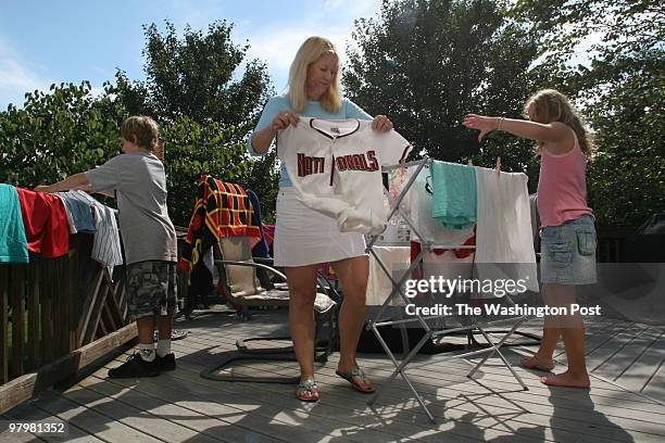 By Dayna Smith/twp Leslie Aun hangs laundry to dry outside on the deck of her Reston home. Homeowner rules don't allow clotheslines. With her are son...