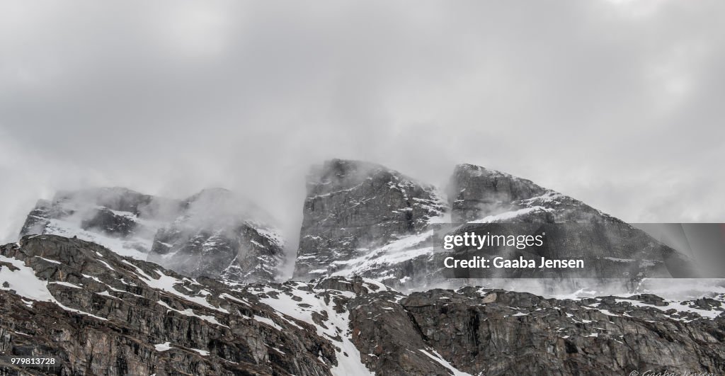 Rocky mountain peaks of Uummannaq fjord in fog, Ukkusissat, Greenland