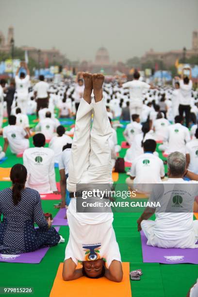 Practitioner does a headstand as he and others take part in a mass yoga session on International Yoga Day at Rajpath in New Delhi on June 21, 2018. -...