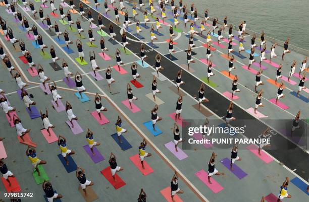 Indian Armed Forces personnel take part in a yoga sesssion to mark International Yoga Day on the Indian Navy aircraft carrier INS Viraat anchored at...