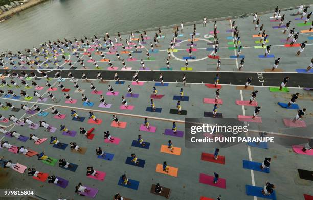 Indian Armed Forces personnel take part in a yoga sesssion to mark International Yoga Day on the Indian Navy aircraft carrier INS Viraat anchored at...