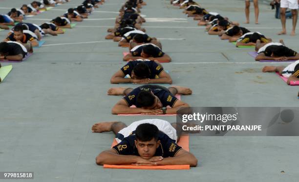 Indian Armed Forces personnel take part in a yoga sesssion to mark International Yoga Day on the Indian Navy aircraft carrier INS Viraat anchored at...