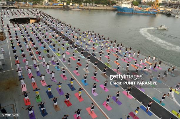 Indian Armed Forces personnel take part in a yoga sesssion to mark International Yoga Day on the Indian Navy aircraft carrier INS Viraat anchored at...