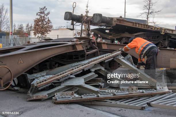 Man working on a destroyed waggon after A switching engine pushed several waggons into a truck at a buffer stop in a freigh depot in Regensburg,...