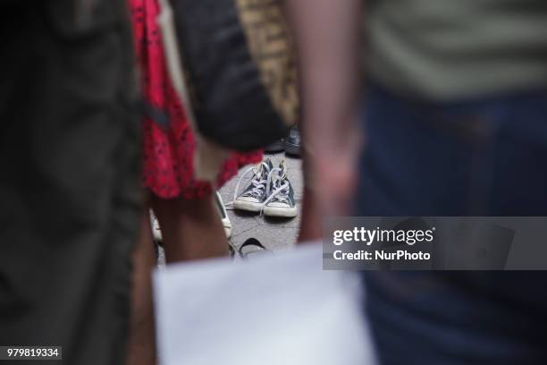 Activists leave their shoes on the ground to represent refugees during a rally to support immigrants and to mark World Refugee Day, June 20, 2018 in...