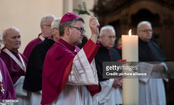 March 2018, Mainz, Germany: Mainz's bishop Peter Kohlgraf, spraying holy water in the direction of the corpse of the recently passed-away cardinal...