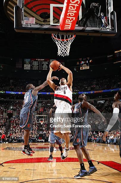 Juwan Howard of the Portland Trail Blazers goes to the basket over Raymond Felton and Nazr Mohammed of the Charlotte Bobcats during the game on...