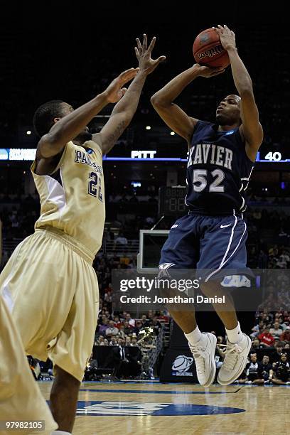 Terrell Holloway of the Xavier Musketeers shoots over Brad Wanamaker of the Pittsburgh Panthers in the second half during the second round of the...