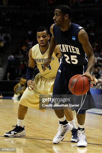 Dante Jackson of the Xavier Musketeers moves the ball against Jermaine Dixon of the Pittsburgh Panthers in the second half during the second round of...