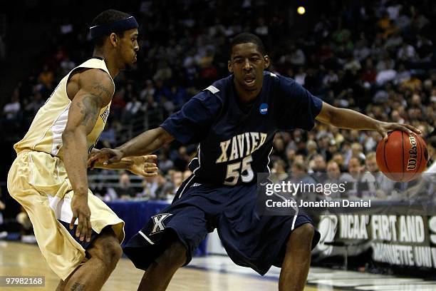 Jordan Crawford of the Xavier Musketeers moves the ball against Gilbert Brown of the Pittsburgh Panthers in the second half during the second round...