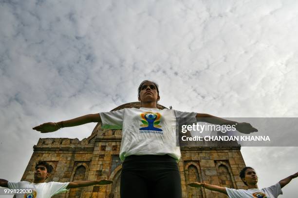 Indian instructors perform during a mass yoga session to mark International Yoga Day next to a Mughal-era tomb in Lodi Gardens in New Delhi on June...