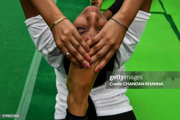 An Indian yoga instructor performs during a mass session along with other practitioners to mark International Yoga Day in Lodi Gardens in New Delhi...