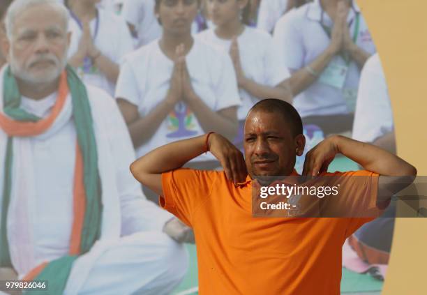 Chief Minister of Uttar Pradesh state Yogi Adityanath, wearing a saffron-coloured Liverpool Football Club shirt, takes part in a yoga session to mark...