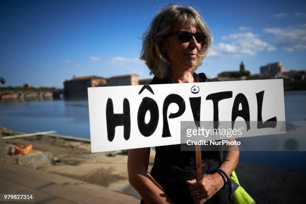 Woman hlods a placard in front of the La Grave hospital in Toulouse during the 'theatrical deambulation'. Several NGOs such as Amnesty International,...