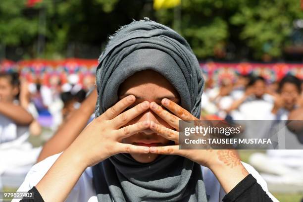 Indian Kashmiri students of the National Cadet Corps take part in a yoga session to mark International Yoga Day in Srinagar on June 21, 2018. -...