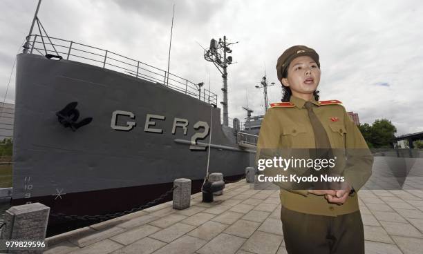 Kim Mi Gyong, a guide at the Victorious Fatherland Liberation War Museum in Pyongyang, talks in front of the U.S. Navy intelligence ship Pueblo that...