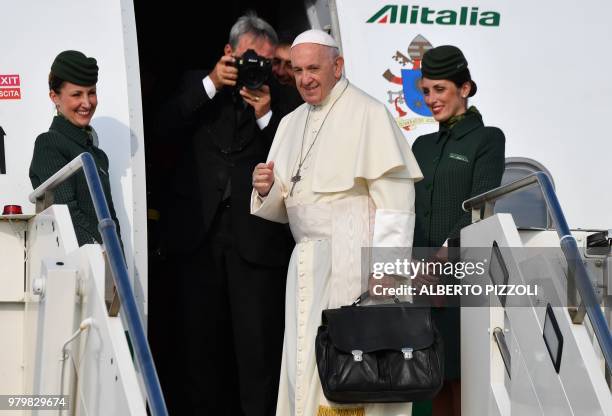 Pope Francis waves on top of the plane steps as he prepares to fly from the Fiumicino airport on June 21 to Geneva for a one day pastoral trip.