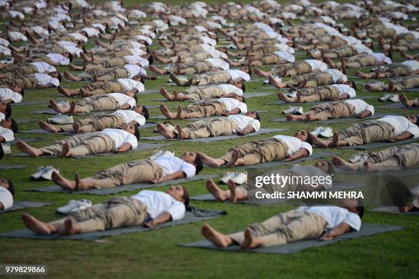 Indian Punjab policewomen take part in a yoga session to mark International Yoga Day in Jalandhar on June 21, 2018. - Downward-facing dogs, cobras...