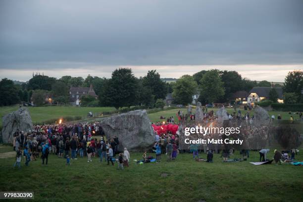 People gather at Avebury Neolithic henge monument, a UNESCO World Heritage site, as they watch a performance of the Kings Drums, after the sun has...