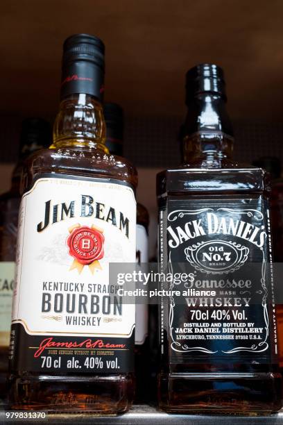 March 2018, Germany, Hamburg: Two bottles of whiskey brands from the United States are stacked on a shelf in a supermarket. The President of the...