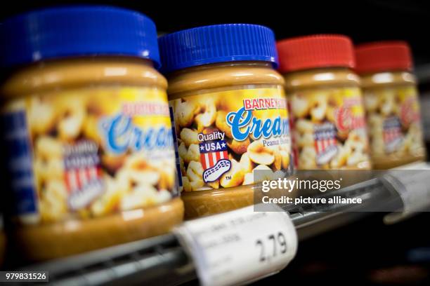 March 2018, Germany, Hamburg: Peanut butter jars from the USA are stacked on a shelf in a supermarket. The President of the European Commission,...